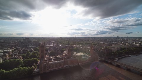 Establishing Aerial View Shot of London UK, United Kingdom, Palace of Westminster, Parliament, Big Ben, day, strong sun and drops of rain, close view, slow push back and hoover 