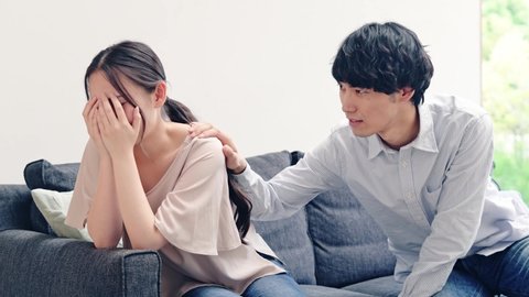 Asian man talking to a crying woman.