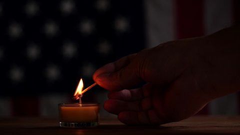 Happy Memorial Day, Man hand lighting memorial candle on American USA flag dark background. Concept of 4th of July, Independence Day, Memorial Day, Veterans Day, Honor, Military, Patriot