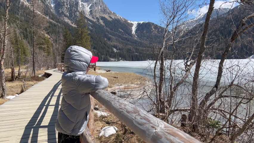 Boy looking at view of forest and snow covered mountain