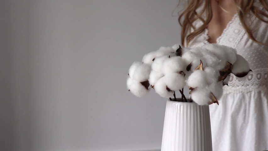 Blonde Girl Takes Sprigs of Natural Cotton from a White Vase. | Shutterstock HD Video #1090644057