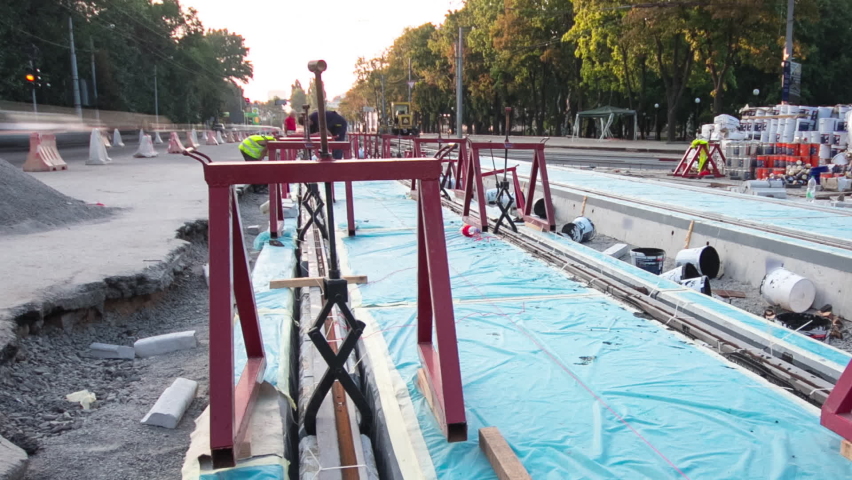 Tram rails at the stage of their installation and integration into concrete plates on the road timelapse hyperlapse. Filling by liquid resin for reduction of vibration and noice. The process of