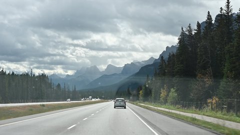 Road trip of car driving on highway and rock mountains in Banff National Park, Alberta, Canada