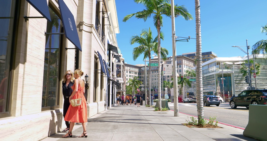 LOS ANGELES, CALIFORNIA, USA - MAY 6, 2022: Tourists walking near luxury boutique shops on Rodeo Drive, Beverly Hills, Los Angeles, California, 4K
