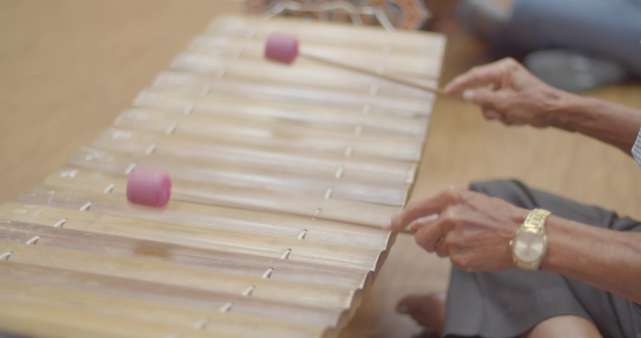 Thai musical instruments. The alto xylophone make a soft sound accompaniment to the rhythm of the music. ( close up hands )