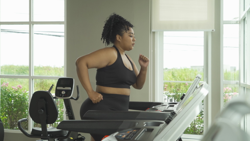 Fat black African american healthy woman, person, running or jogging on treadmill for diet, and training in gym or fitness center in sport and recreation concept. Lifestyle activity. Losing weight Royalty-Free Stock Footage #1090647091