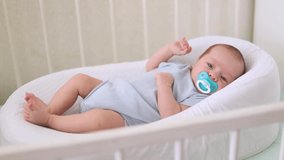 The baby is lying in a cocoon for newborns. Anti-colic cocoon. High quality FullHD footage