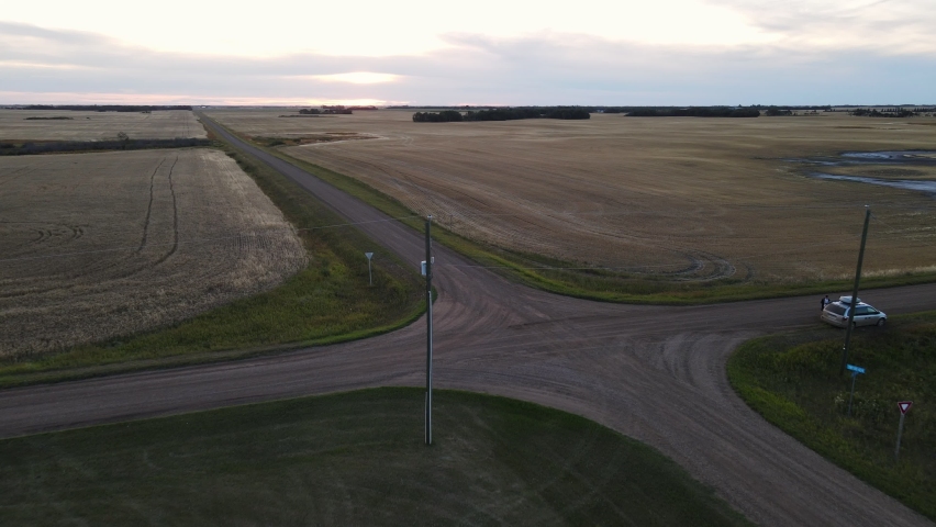 An ancient christian church made from wood behind a small patch of deciduous trees in rural Alberta. Wide angle revealing drone footage