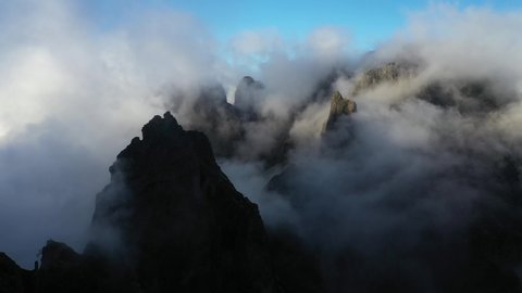Drone shot moving forward among the peaks of Pico das Torres in Madeira.