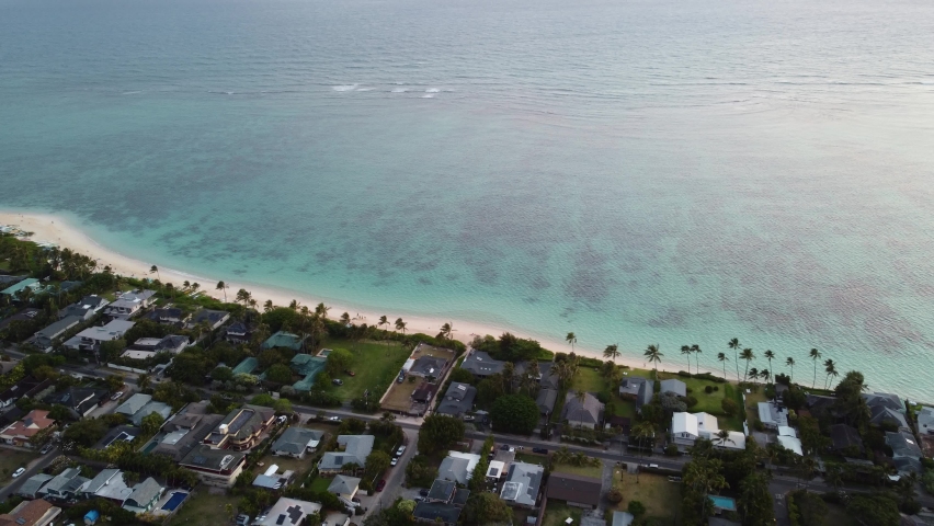 4K cinematic aerial shot of the white sands and calm water at Lanikai Beach in Oahu during sunrise. This relaxing scene was filmed in Hawaii using a DJI Mini 2 drone Royalty-Free Stock Footage #1090649637