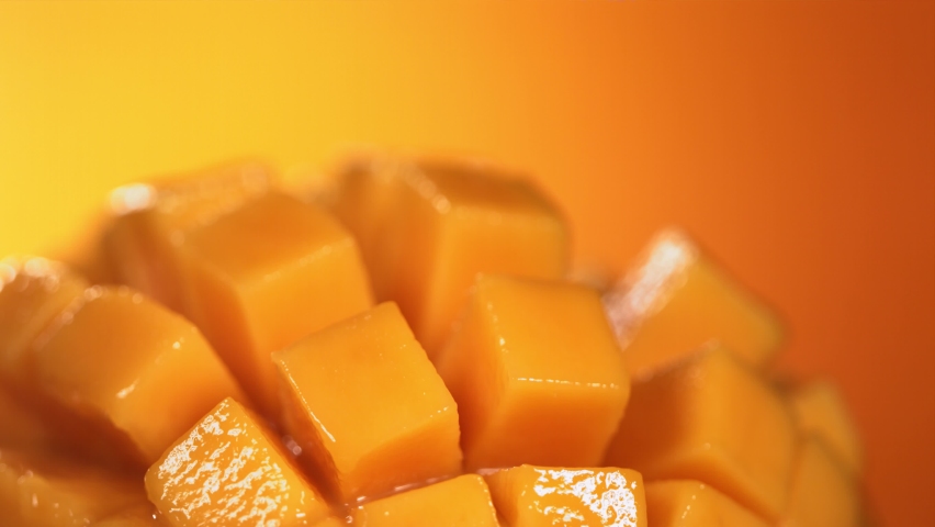 Slow Motion Shot of Mango Juice Splashing through Mango Cube Slices Royalty-Free Stock Footage #1090650039