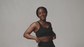 African american girl wearing sportive clothes posing smiling in studio. Slimming, fitness and body positive. ProRes