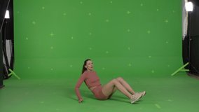 GREEN SCREEN CHROMA KEY Young sporty female coach talking to the camera and showing exercises. Online workout training, VR or mobile fitness application 