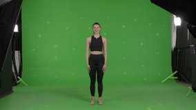 GREEN SCREEN CHROMA KEY Young sporty female yoga or pilates coach talking to the camera and showing exercises. Online workout training, VR or mobile fitness application 