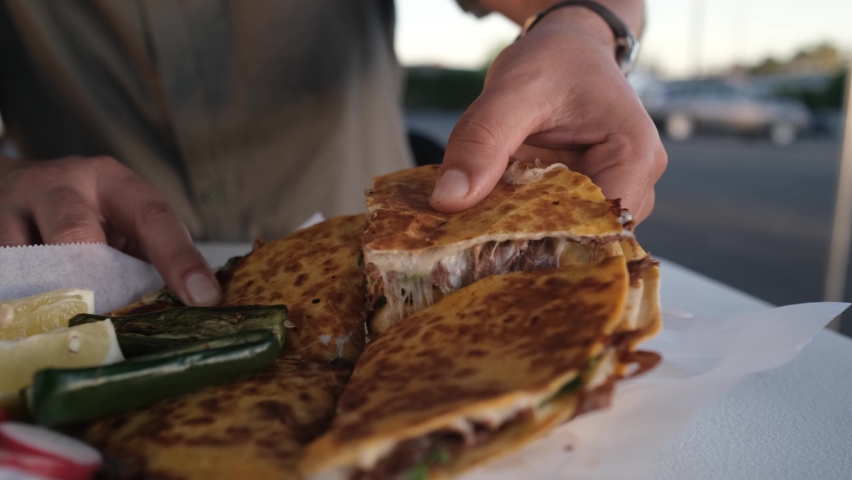Young Hispanic Man Enjoying a Quesabirria Pizza Slice