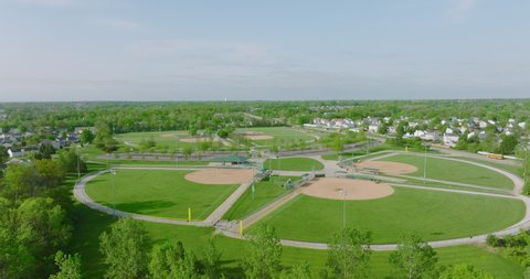 St. Louis , MO , United States - 05 22 2022: Flying Over Baseball Diamonds, Aerial Drone Shot of Bright Green Baseball Fields on Sunny Day 