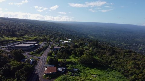 4K cinematic drone reveal shot of cars driving down a road near Kona on the Big Island of Hawaii. This stunning scene, revealing the ocean in the background, was filmed using a DJI Mini 2 drone.