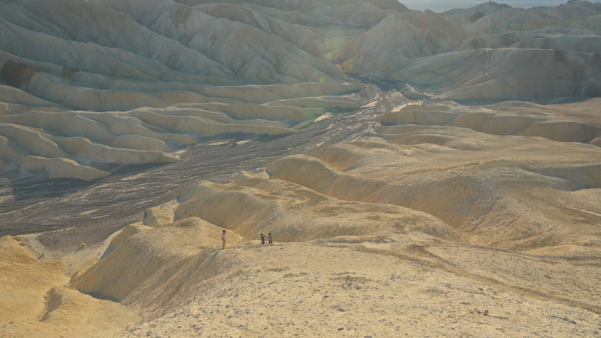 People stand in distance on rocks at Death Valley National park.