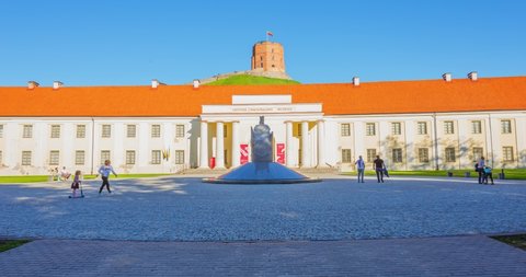 MAY 23, 2022: City center in Vilnius with National Museum of Lithuania and Gediminas statue and Castle, Lithuania at spring, people walking in the park, 4k tilting timelapse