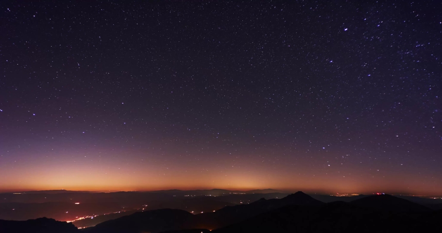 The stars revolve in the starry night sky over the mountains. 4K timelapse video  Royalty-Free Stock Footage #1090666625