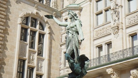 HAMBURG, GERMANY - MARCH 27, 2022: Statue of Hygieia, the goddess of health and hygiene in Greek mythology, on a fountain in the Courtyard of the historic City Hall of Hamburg on a sunny spring day