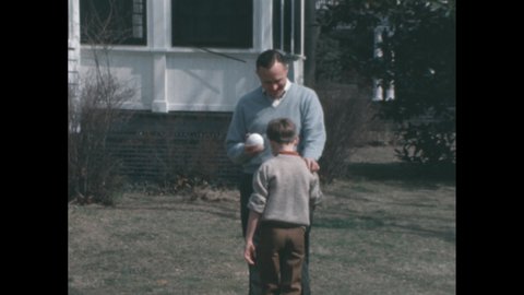 1960s: boy and man walking away to sit down after playing catch, boy and man arm wrestling at picnic table