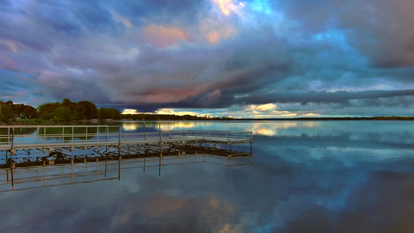 Amazing colorful clouds and sky reflected in tranquil lake at daybreak
