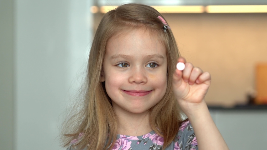 Happy little girl holds pill in hands and fun eats vitamin. Medicines, medicament and drug. Health, care and treatment for children. Royalty-Free Stock Footage #1090673961