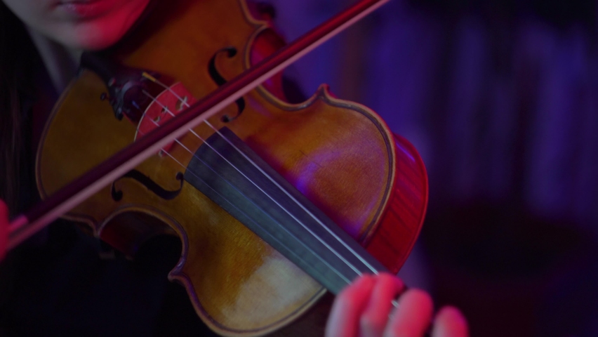 
Girls plays the violin close-up. Close-up of playing the violin.Hands playing the violin.Neon light violinist.The violinist plays in the dark with neon color close-up. | Shutterstock HD Video #1090677061