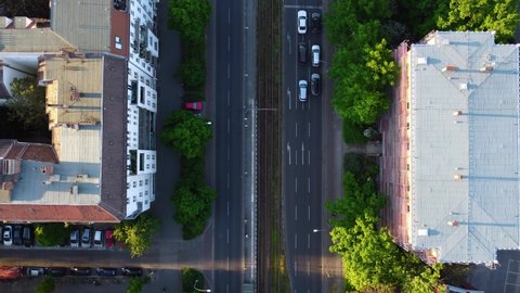 Camera tracks cars Traffic, wait at an intersection and drive off Smooth aerial view flight Drone top-down view of Berlin Prenzlauer Berg Allee Summer 2022. 