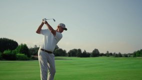 Senior golf player practicing hitting ball on grass field. Man training on fairway course. Pensioner enjoy rich life activity on weekend. Golfer play swinging putter club outdoors. Recreation concept. - Powered by Shutterstock - Get 15% off with code: PIKWIZARD15