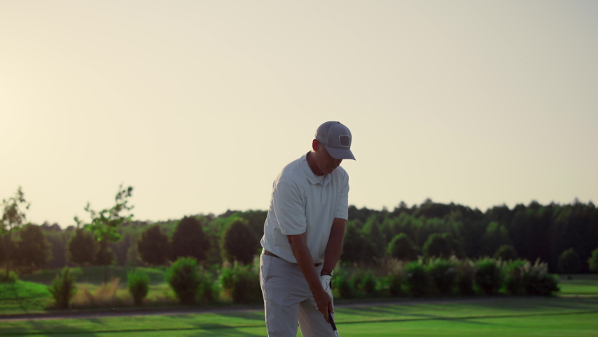 Golf player teeing club putter on sport training. Rich man having fun on luxury vacation outside. Focused golfer enjoy active retirement on course. Golfing player hitting ball on play. Wealthy concept Royalty-Free Stock Footage #1090684019