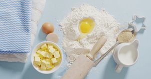 Video of baking ingredients, muffin papers, eggs and tools lying on white surface. baking, food preparing, taste and flavour concept.