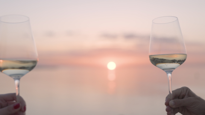 Two hands making a cheers with wine glass against sparkling sea and sky at sunset Royalty-Free Stock Footage #1090689711