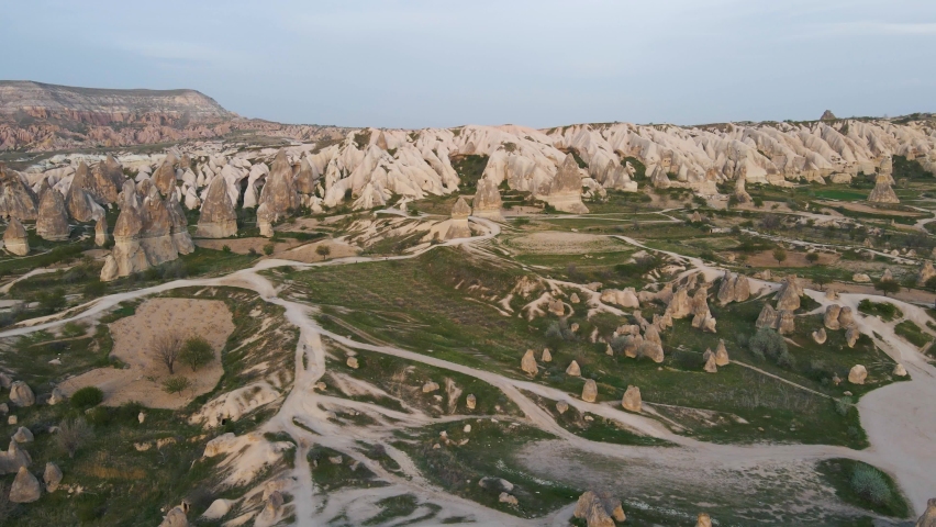 Aerial drone rotating shot over scenic landscape with rocks unusual a formation called fairy chimneys in Goreme,Cappadocia, Turkey. Road network visible.