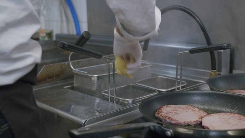 A professional chef is cooking Italian pasta and hamburgers