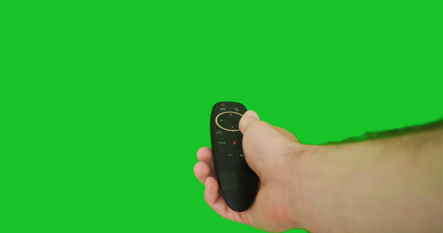 A man's hand holds a remote control from a smart TV and clicks on it, turns it on, off, sets the menu on the chroma key. Green screen, close-up, first-person view, pov | Shutterstock HD Video #1090706695
