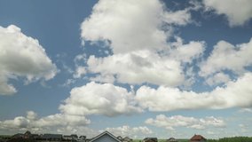 Cloudscape timelapse. Beautiful sunny day with village and blue sky with white fluffy clouds. Time lapse video