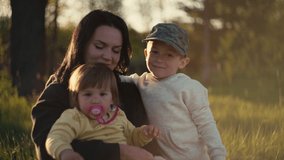 Mom plays with children in the park on the grass. Boy girl and woman happy family in nature smiling and having fun. - Powered by Shutterstock - Get 15% off with code: PIKWIZARD15