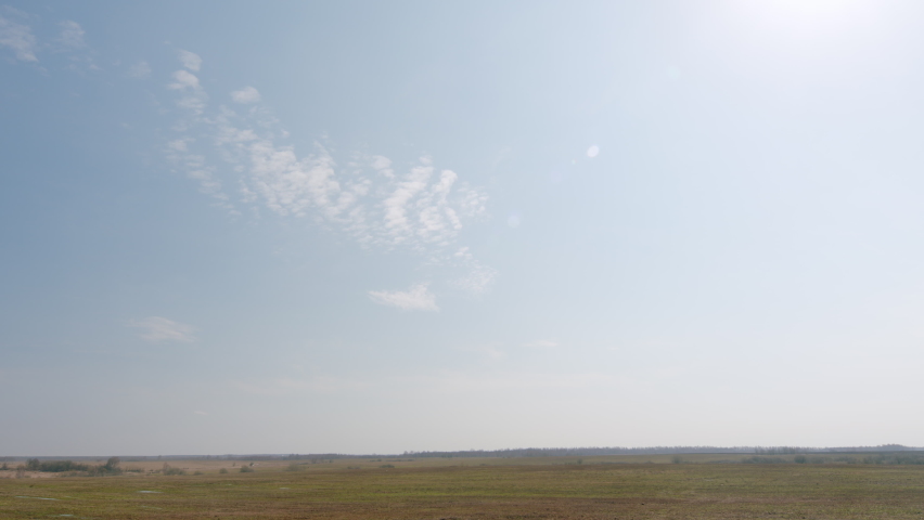 Meadow and puddle under beautiful sky. Early spring with puddles of water in fields.