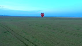 Spectacular hot air balloon flying above field with beautiful blue sky. Footage from a bird's eye view. Location place Ukraine, Europe. Cinematic drone shot. Filmed in UHD 4k video. Beauty of earth.