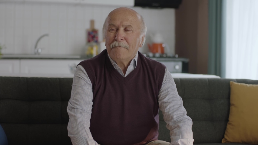 Worried, pensive, 80s old man sitting at home alone, thinking about life alone.Depressed pensive old man with health problems in old age feels lonely. Old age diseases, healthcare concept.