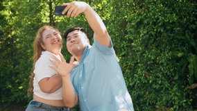 Fat Asian couple using mobile phone for video calls, conferences, teleconferencing with family. Man and woman switch on record on smartphone vlog dancing at home. shoot funny clip from domestic party
