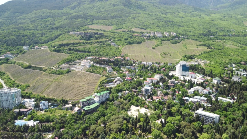 Aerial panoramic view on Gurzuf resort city and Bear Mountain, Ayu-Dag, Yalta, Crimea. Spring sunny day. Nature summer ocean sea beach background. Vacation, travel and holiday concept.