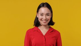 Smiling charming vivid young woman of Asian ethnicity 20s years old wears red shirt looking camera wink eye blink isolated on plain yellow background studio portrait. People emotions lifestyle concept - Powered by Shutterstock - Get 15% off with code: PIKWIZARD15