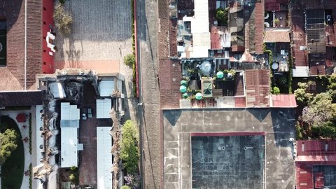 Aerial footage over the rooftops of Antigua, Guatemala with the surrounding volcanoes in the background