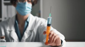 Girl doctor doctor holds in his hand a syringe releasing a jet. Doctor woman's hand holding a syringe, Medical syringe in hand closeup, Health care concept doctor in a smock at the workplace
 - Powered by Shutterstock - Get 15% off with code: PIKWIZARD15