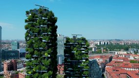 Aerial 4K footage of a Vertical Forest building with many plants integrated to its facade - a pair of residential towers in Milan, Italy. Milan city skyscrapers video