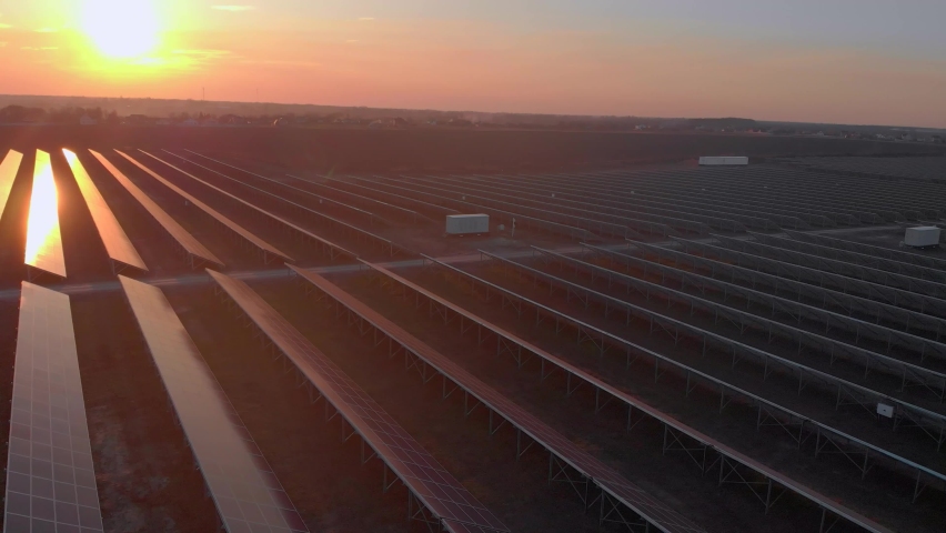 Aerial drone view of large solar panels at a solar farm at bright sunset in early winter. Solar cell power plants Royalty-Free Stock Footage #1090735003