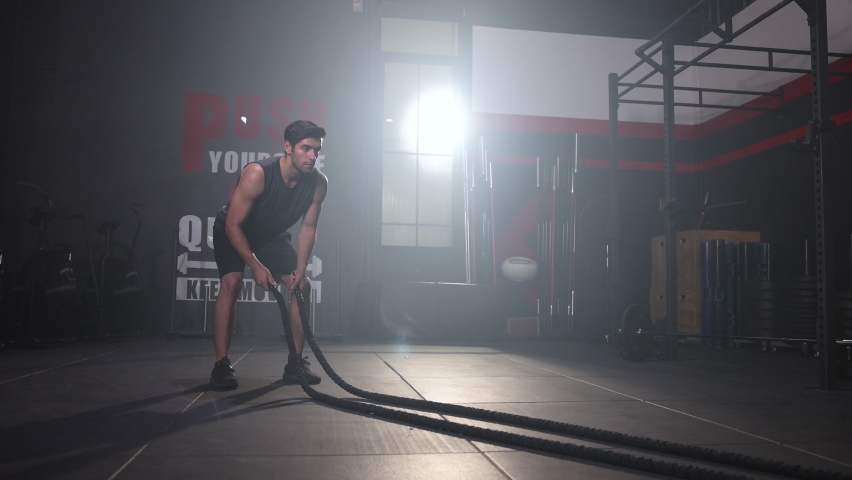 Man Using Battle Ropes For Whipping Exercise  in a Gym Royalty-Free Stock Footage #1090736119